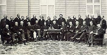 Photographie en noir et blanc d'une trentaine de participants de la Conférence de Québec en demi-cercle (la moitié sont debout, les autres, assis).