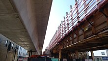 The project replaces embankment tracks (right) with elevated box girder tracks (left), located under the temporarily closed Lawrence station Red Purple Modernization construction at Lawrence.jpg