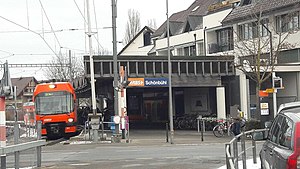 Roter Zug neben überdachtem Bahnsteig