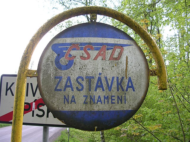 Traditional sign of a request stop of the former Czechoslovak national bus operator ČSAD (the sign translates to "bus stop on request".)
