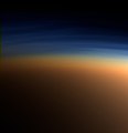Echtfarbaufnahme der oberen Titan­atmosphäre. In der blauen Dunst­schicht brechen Methan­moleküle auf, darunter liegt der orange­farbene Dunst. Aufnahme aus 9500 km Ent­fer­nung, die Auf­lösung beträgt ca. 400 m pro Pixel (Cassini, 2005)