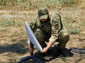 Support Forces of Ukraine soldier installing a Starlink terminal. UA Support Forces Starlink 01.jpg