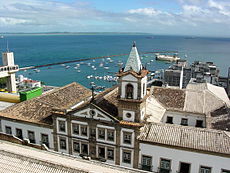 Vista aérea sobre as edificações históricas do Centro e ao fundo à esquerda, o Elevador Lacerda e a Baía de Todos-os-Santos com o Forte de São Marcelo ao centro.