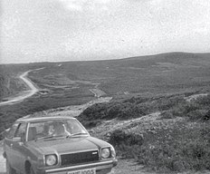 Fotografia di Wade's Causeway, scattata intorno al 1978, che mostra un'auto del periodo parcheggiata all'inizio della sezione Skvick della struttura