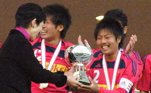 Princess Takamado presenting the Prince Takamado Trophy to the captain of the winning team at the 2013 Prince Takamado Cup U-18 Soccer League Champion