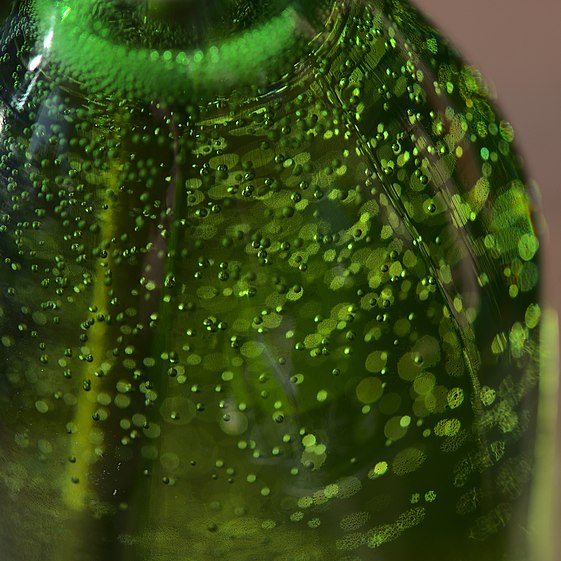 Green bottle with sparkles and bokeh