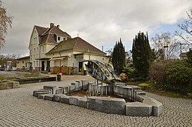 Bahnhofsgebäude (hinten) und Walldorfer Brunnen (vorne)