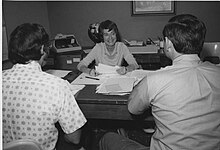 Barbara Crawford Johnson speaks to co-workers in her office, circa 1970-1974. Barbara at work.jpg