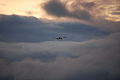Boeing 777 descending to SFO, lovely clouds and fog ahead of it (7141404529).jpg