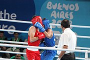 Deutsch: Boxen bei den Olympischen Jugendspielen 2018 Tag 12, 18. Oktober 2018 - Kampf um Bronze im Leichten Weltergewicht Jungen – Hassan Azim (Großbritannien, rot) schlägt Mohammed Boulaouja (Marokko, blau) RSC; Ringrichter ist Wulfren Olivares Peréz (Kolumbien). English: Boxing at the 2018 Summer Youth Olympics on 18 October 2018 – Bronze Medail Match Light Welterweight Boys - Hassan Azim (Great Britain, red) beats Mohammed Boulaouja (Morocco, blue) RSC; Referee is Wulfren Olivares Peréz (Columbia). Español: Boxeo en los Juegos Olímpicos Juveniles de Verano de 2018 en 18 de octubre de 2018 - Medalla de bronce de los hombres ligeros de peso welter: Hassan Azim (Gran Bretaña, rojo) vence a Mohammed Boulaouja (Marruecos, azul) RSC; El árbitro es Wulfren Olivares Peréz (Colombia).