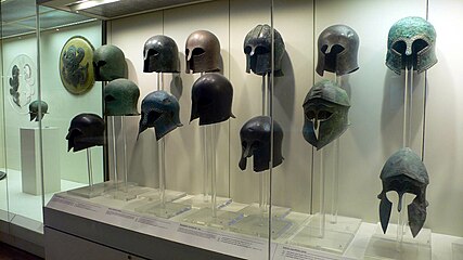 Vitrina de cascos de tipo corintio, de bronce, arcaicos.