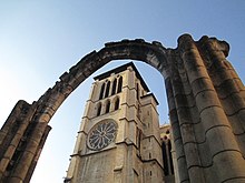 Photographie couleur montrant une tour de l'actuelle cathédrale prise à travers une arche.