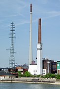 Rechtes Rheinufer Duisburg-Hochfeld. Links: Mast der Freileitungskreuzung über den Rhein, Mitte: Schornstein der Sinteranlage der DK Recycling GmbH. Höhe: 250 m