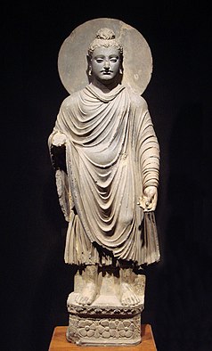 standing Buddha statue with draped garmet and halo