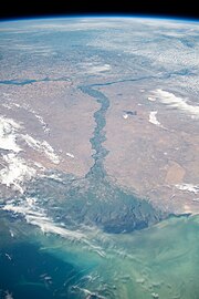 Grande fiume che termina in un delta triangolare nel mare, visto dall'alto dell'atmosfera