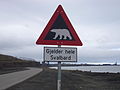 Skilt som advarer om fare for å møte en isbjørn og det er skrevet bokstavelig Gyldig på alle Svalbard øyer