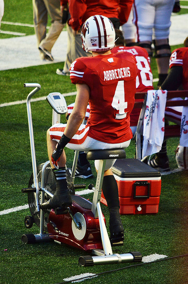 Abbrederis riding a stationary bike on the sideline during a game against Ohio State in 2012