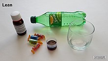 Ingredients for creating lean, including codeine-promethazine cough syrup, Jolly Rancher candies, and Sprite. Note the label on the bottled syrup, printed with instructions on how to prepare the lean. Some of the syrup has been decanted into a plastic container. Lean drug ingredients.jpg