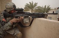 A U.S. 2nd Infantry Division soldier pulls security on top of a roof using an M240B with an attached M145 (ARD) and AN/PEQ-2.