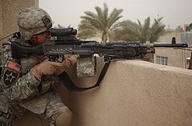A U.S. 2nd Infantry Division soldier pulls security on top of a roof using an M240B with an attached M145 (ARD) and AN/PEQ-2