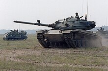 An M60A3 main battle tank (foreground) and an M113A1 armored personnel carrier (left background) from the 108th Armored Regiment, Georgia National Guard, move out to attack opposing forces. The training Exercise COMPANY TEAM DEFENSE 1983 is being conducted in preparation for annual training to be held at Fort Irwin, California. M60A3 (foreground) and M113A1 (left background), 108th Armored Regiment, Georgia National Guard.jpg