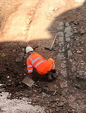 An archaeologist working on the cobbled street, June 2018 Mediaeval Cobblestone Road Birmingham.jpg