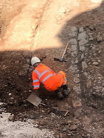 An archaeologist working on the cobbled street, June 2018