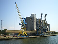 Le quai de Blainville sur la rive Est du Canal de Caen à la mer avec ses grues et les silos à blé d'Agrial.
