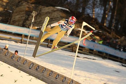 Robert Kranjec using a wide V-style with skis almost crossed at the back, 2012