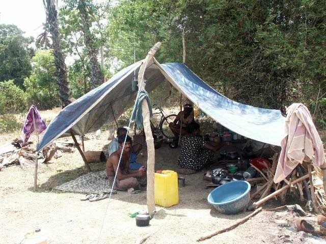 Photo release by the Tamils Rehabilitation Organisation dipicting a shelter built from tarp and sticks. Pictured are displaced people from the Sri Lan