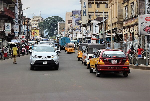 A normal day Freetown street with "Keke", regular taxis and private vehicles on the road