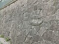 Pochstempelstein („Amboss“, sekundär in eine Stützmauer eingesetzt) und Stützmauer