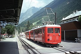 Train en gare avec les premières centaines de mètres de vois du chemin de fer du Montenvers en arrière-plan.