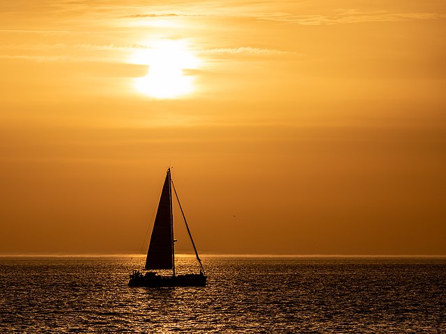 Парусная лодка в Западной Шельде, освещённая контровым светом заходящего солнца