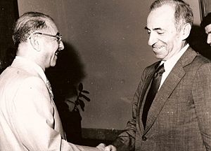 Black-and-white photo of two men in suits, shaking hands