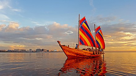 Balangay boat with gaff rigs in Manila Bay at sunset