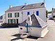 Le puits de Locmaria à Belle-Île-en-Mer. Ce puits se trouve en haut de la place de Méaudre, dominant l'église. Il est abrité dans un édicule carré coiffé d'un toit pyramidal en ardoise. Dans une niche perchée au bord du toit, une Vierge surveille la pompe peinte en bleu qui actionne ce puits.