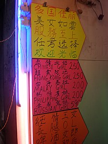 A handwritten sign advertising the prices for various nationalities of women outside a brothel on Soy Street in Kowloon. Brothel price sign for various nationalities on Soy St., HK.JPG