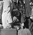 A group of American citizens waiting to get on a bus that will take them to an internment camp