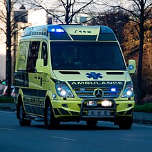 An ambulance in Denmark with roof-integrated LED lights, plus side-view mirror, grill and front fend-off lights, and fog lamps wig-wags DNK ambulance A6.jpg