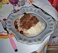 Plat de viande en sauce avec du riz et des olives noires