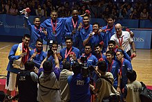 Foto del equipo, con cada miembro uniformado de azul con una medalla de oro.