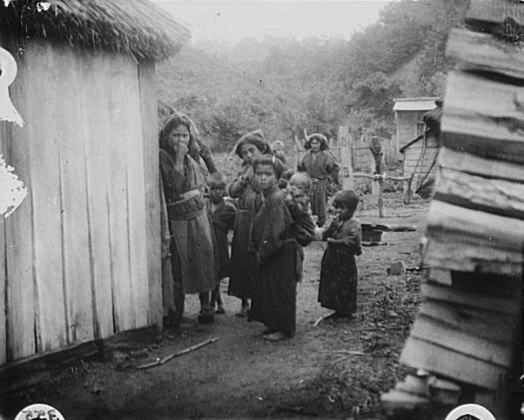 File:Group of Ainu children standing in a passageway between huts LOC agc.7a10205.tif