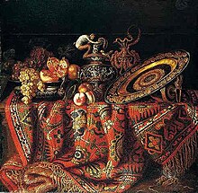 Hupin, Jacques - -Uma natureza morta de pêssegos, uvas e romãs em uma tigela de estanho, um prato de ormolu ornamentado e jarras, tudo descansando sobre uma mesa coberta com um tapete - século 17.jpg