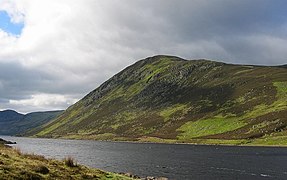 Loch Turret. Looking across the reservoir to Choinneachain Hill. The striking greens are due to the spring growth of Blaeberry/Wimberry (Vaccinium myrtillus)