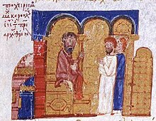 Miniature médiévale représentant un ecclésiastique barbu assis sur un siège.