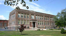 Plymouth's 1913 high school building was designed by architect Alfred Freeman. The portion to the far right, fronting Wadhams Street, was added later. Plymouth's Third High School Building.jpg