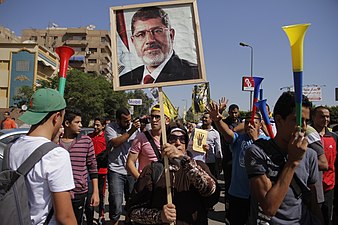 Mursi-loyale Demonstrantin mit Porträt des vom Militär gestürzten Präsidenten.[335]
