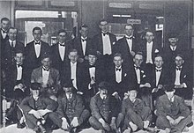 Railway Club em Oxford, idealizado por John Sutro, dominado por Harold Acton.  Da esquerda para a direita, atrás: Henry Yorke, Roy Harrod, Henry Weymouth, David Plunket Greene, Harry Stavordale, Brian Howard.  Fila do meio: Michael Rosse, John Sutro, Hugh Lygon, Harold Acton, Bryan Guinness, Patrick Balfour, Mark Ogilvie-Grant, Johnny Drury-Lowe;  frente: porteiros.