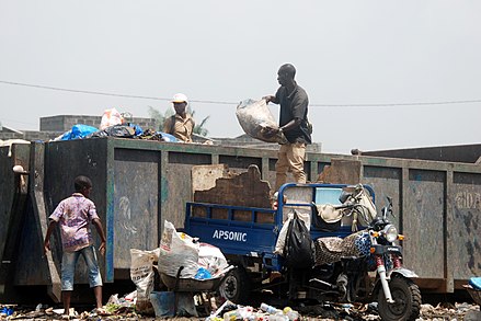 Un collecteur d'ordures ménagères vidant sa cargaison à Abidjan, en Côte d'Ivoire.